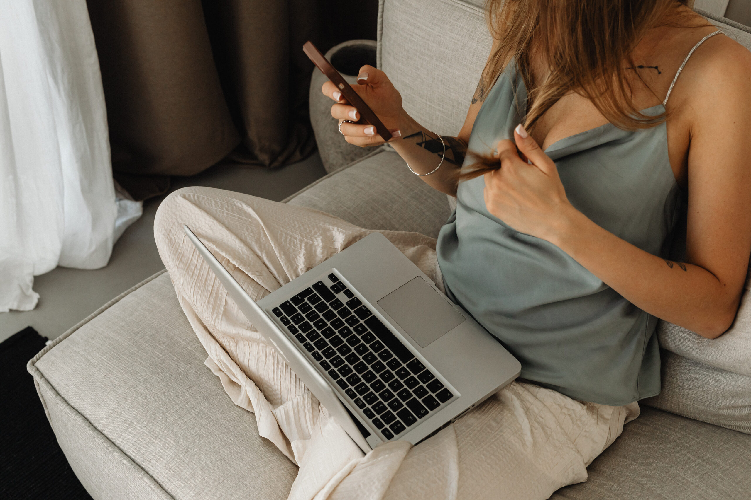 自宅でMACとiPhoneでネットを楽しんでいる女性